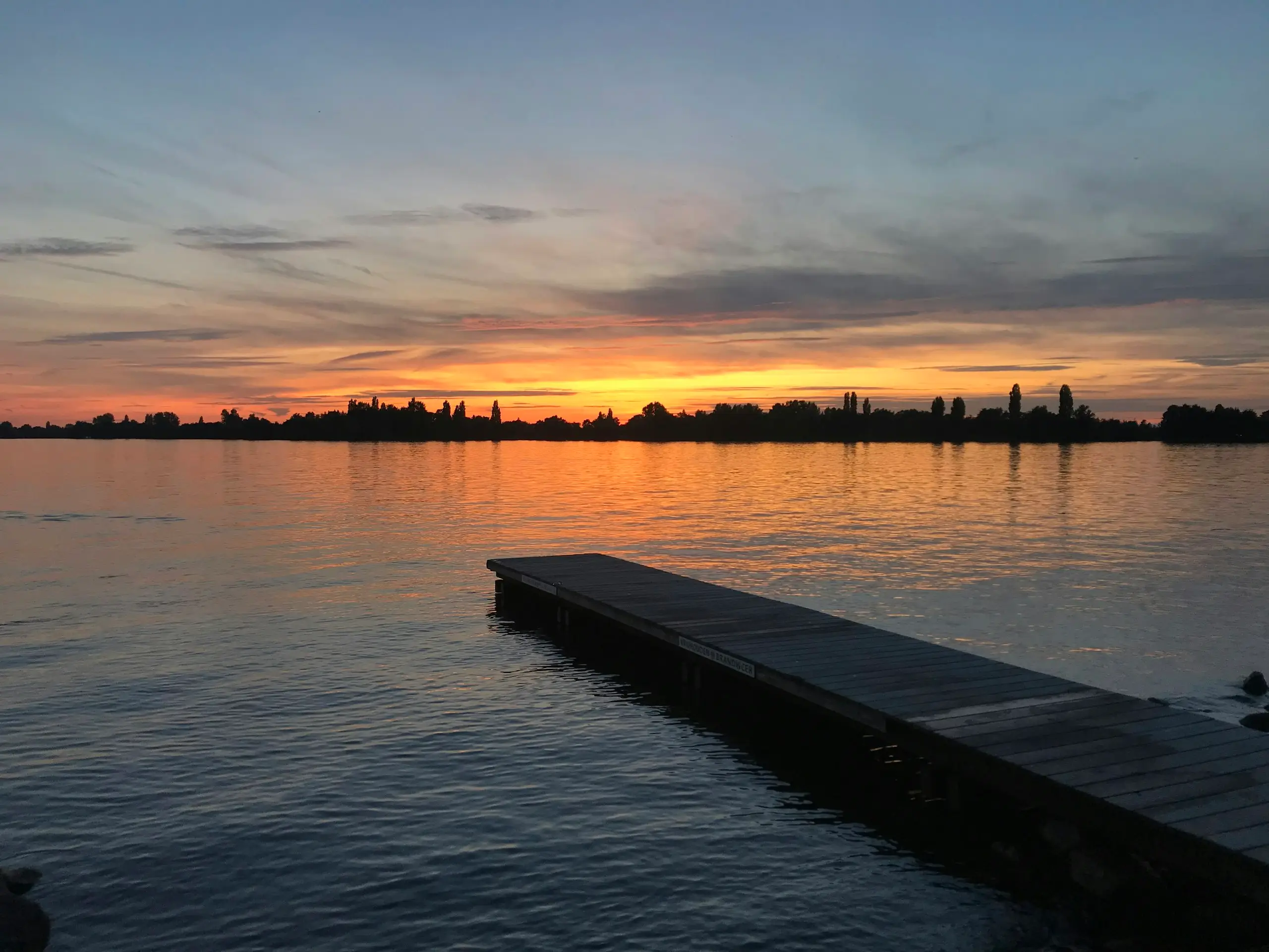 Un ponton en bois sur un lac au coucher du soleil